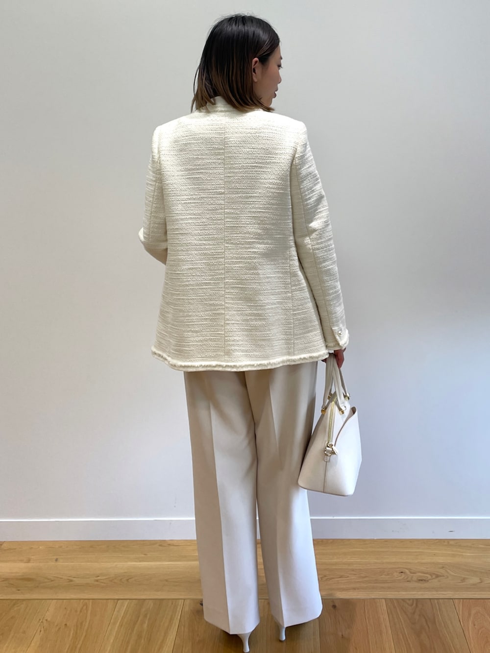 ホワイト系のノーカラージャケット、ホワイト系のシャツ/ブラウス、ベージュ系のその他パンツを着用したレディースの冬コーディネートの3枚目の写真