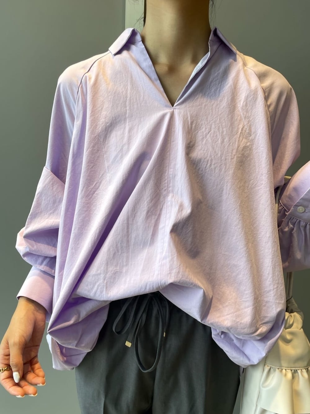 パープル系のシャツ/ブラウス、グレー系のその他パンツ、ホワイト系のショルダーバッグを着用したレディースの秋コーディネートの9枚目の写真