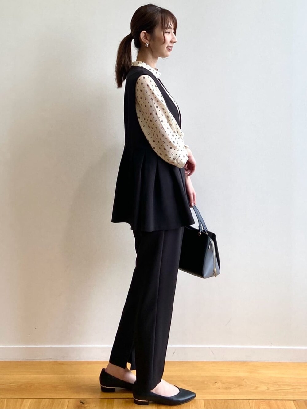 ブラック系のその他パンツ、ブラック系のパンプス、ホワイト系のシャツ/ブラウスを着用したレディースの夏コーディネートの4枚目の写真