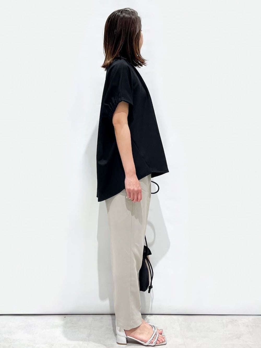 ブラック系のTシャツ/カットソー、グレー系のその他パンツ、シルバー系のサンダルを着用したレディースの春コーディネートの6枚目の写真