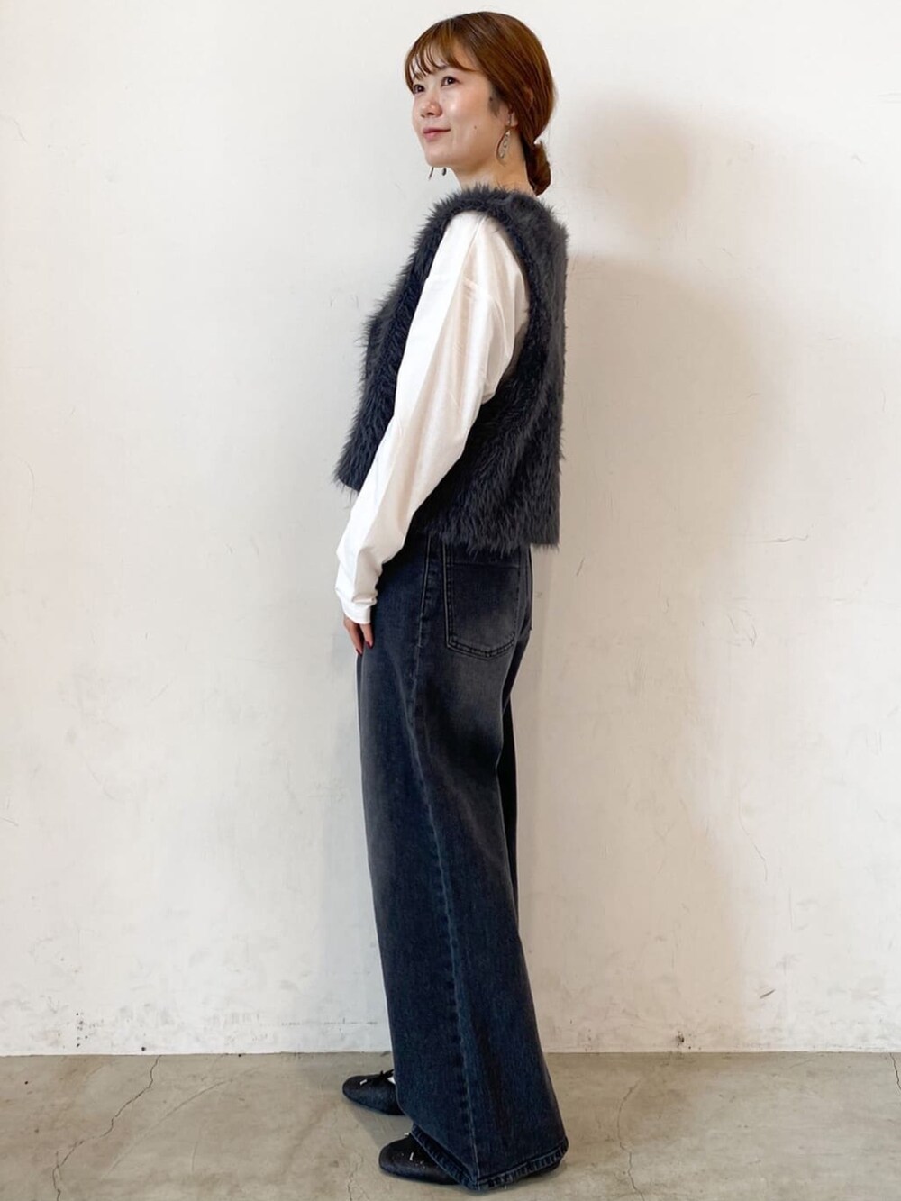 ホワイト系のTシャツ/カットソー、グレー系のベスト、ブラック系のデニムパンツを着用したレディースの秋コーディネートの2枚目の写真