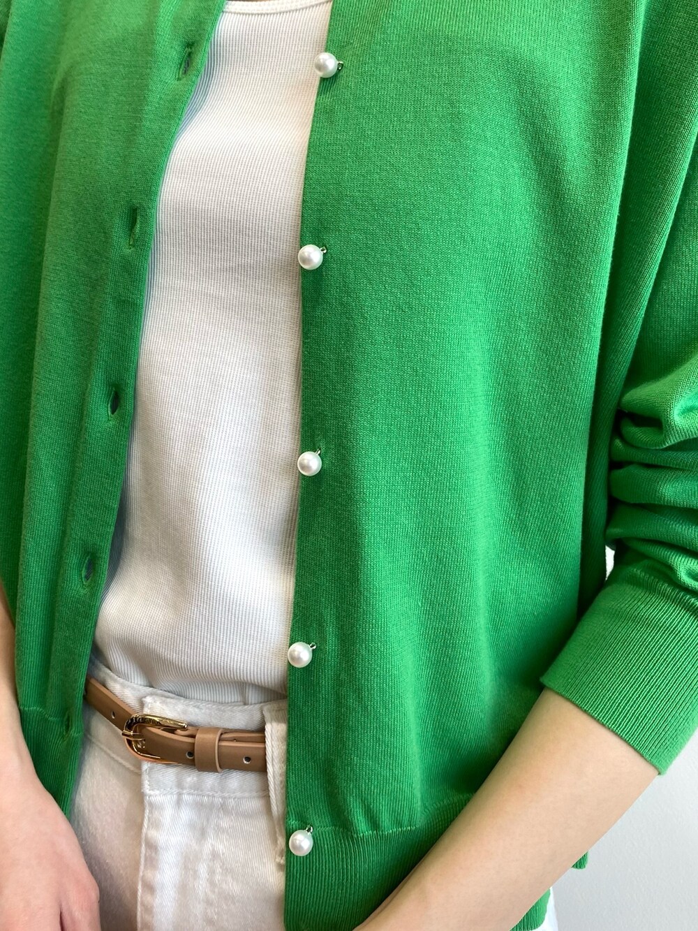 ブラウン系のサンダル、ホワイト系のショルダーバッグ、ホワイト系のデニムパンツを着用したレディースの春コーディネートの5枚目の写真