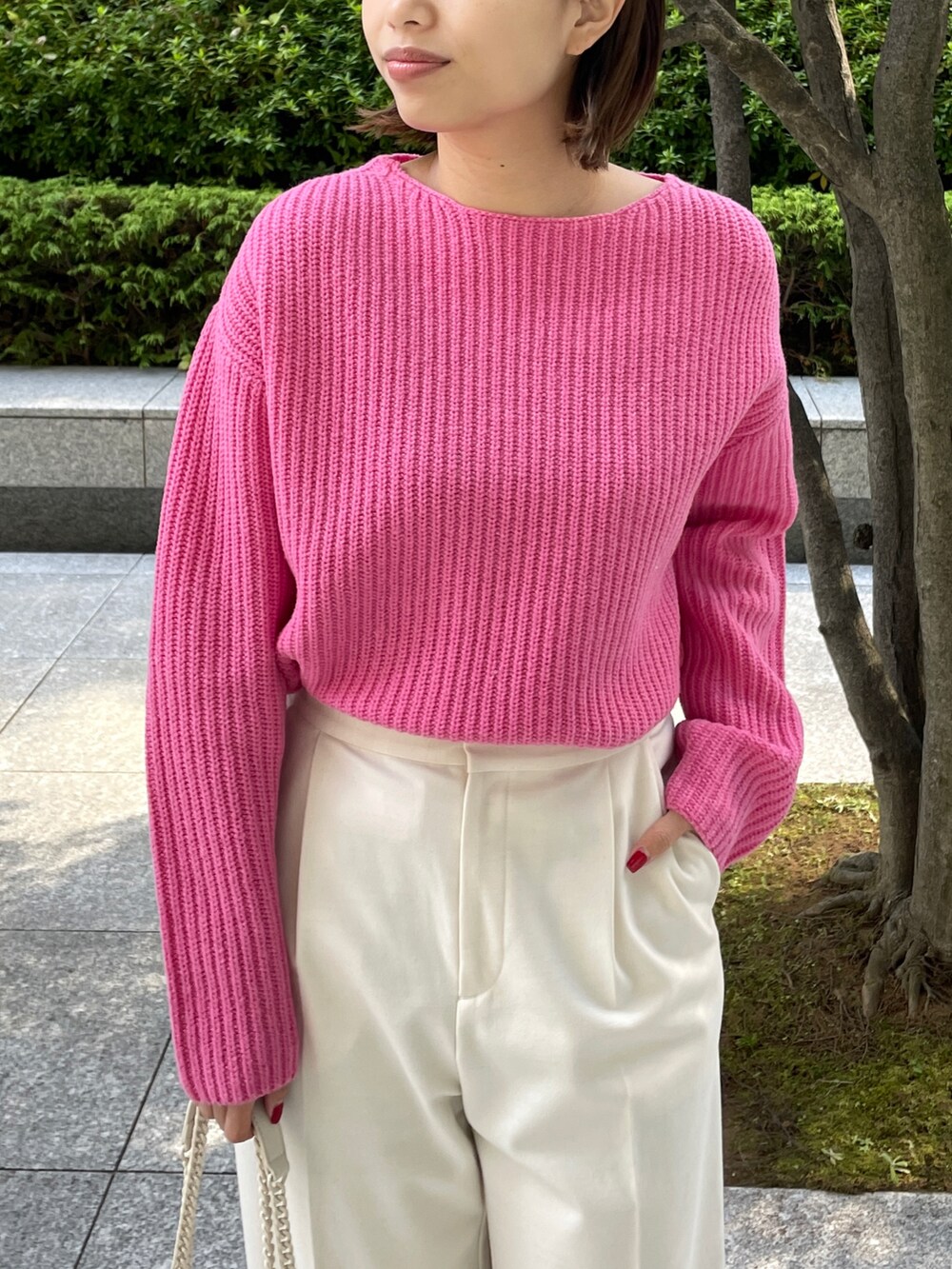 ピンク系のニット/セーター、ベージュ系のチェスターコート、ホワイト系のブーツを着用したレディースの秋コーディネートの4枚目の写真