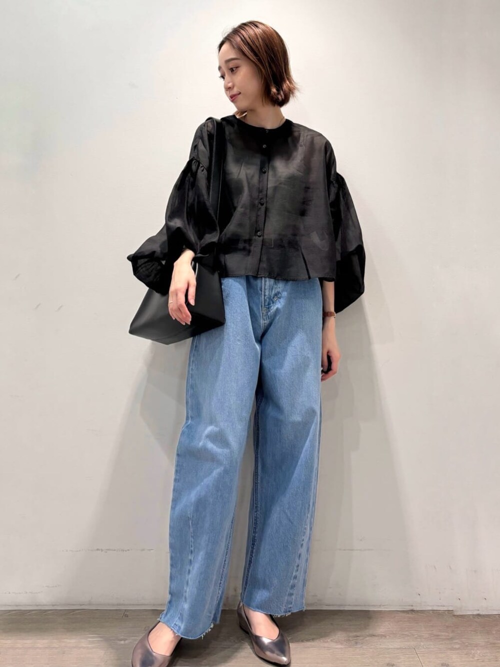 ブラック系のシャツ/ブラウス、シルバー系のパンプス、ブルー系のデニムパンツを着用したレディースの夏コーディネートの2枚目の写真