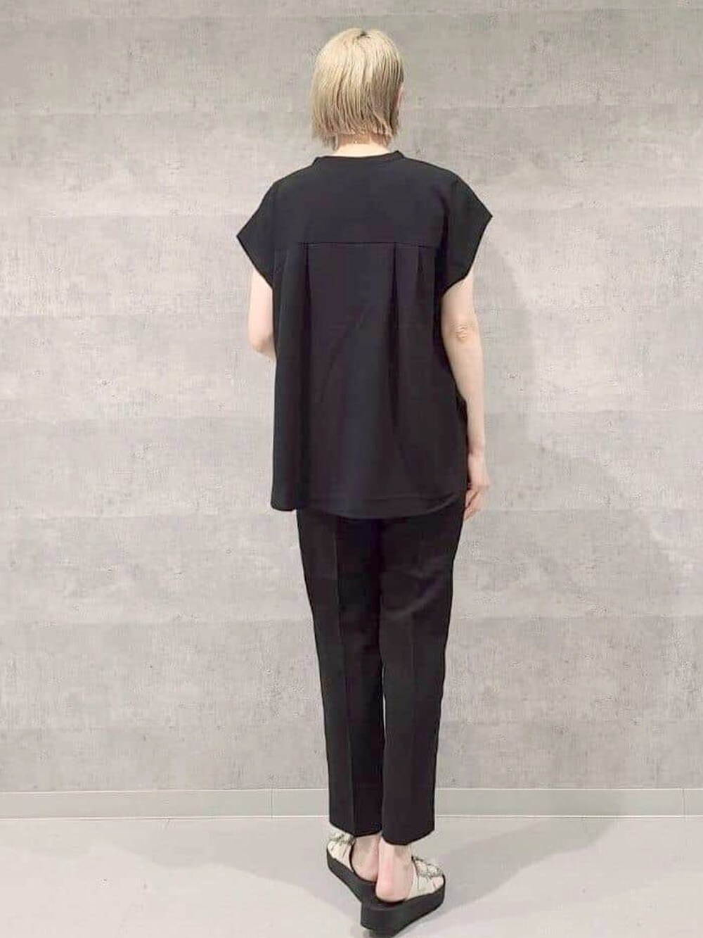 ブラック系のシャツ/ブラウス、ブラック系のその他パンツ、ホワイト系のサンダルを着用したレディースの夏コーディネートの2枚目の写真