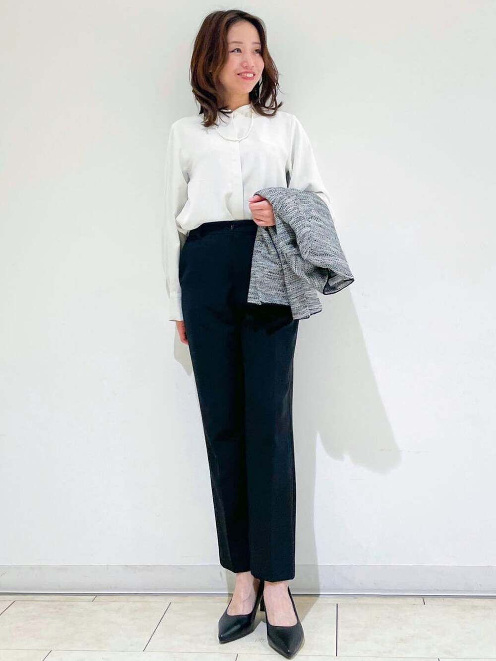 ブラック系のノーカラージャケット、ホワイト系のシャツ/ブラウス、ブラック系のその他パンツを着用したレディースの冬コーディネートの4枚目の写真