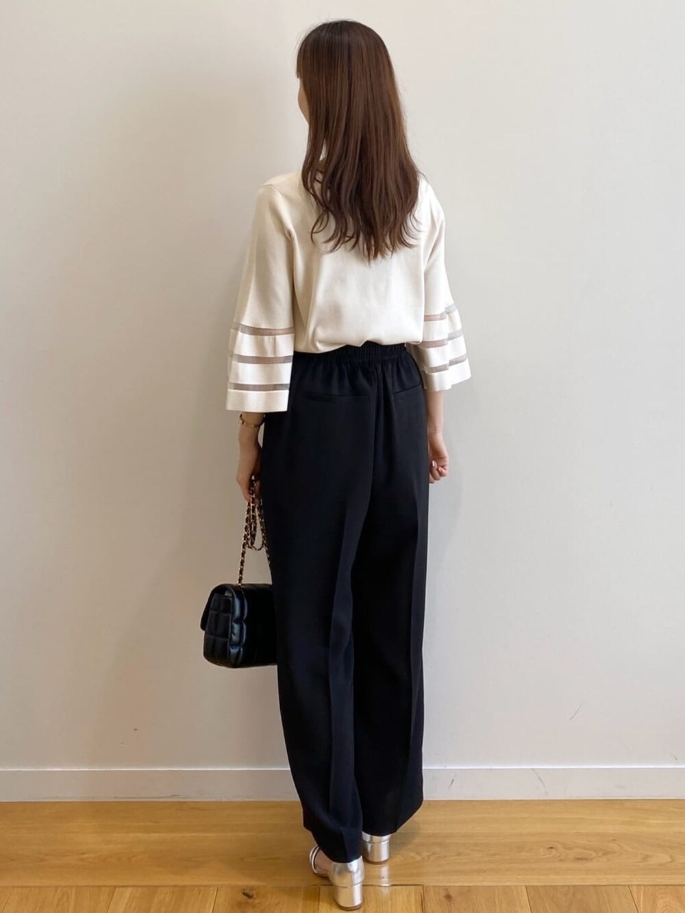 ホワイト系のニット/セーター、ブラック系のその他パンツ、ブラック系のショルダーバッグを着用したレディースの春コーディネートの4枚目の写真