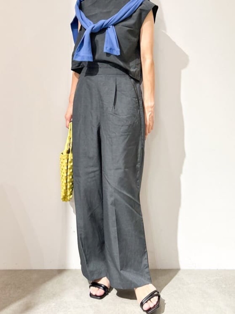 グレー系のサロペット/オーバーオール、ブルー系のカーディガン/ボレロ、イエロー系のハンドバッグを着用したレディースの夏コーディネートの2枚目の写真