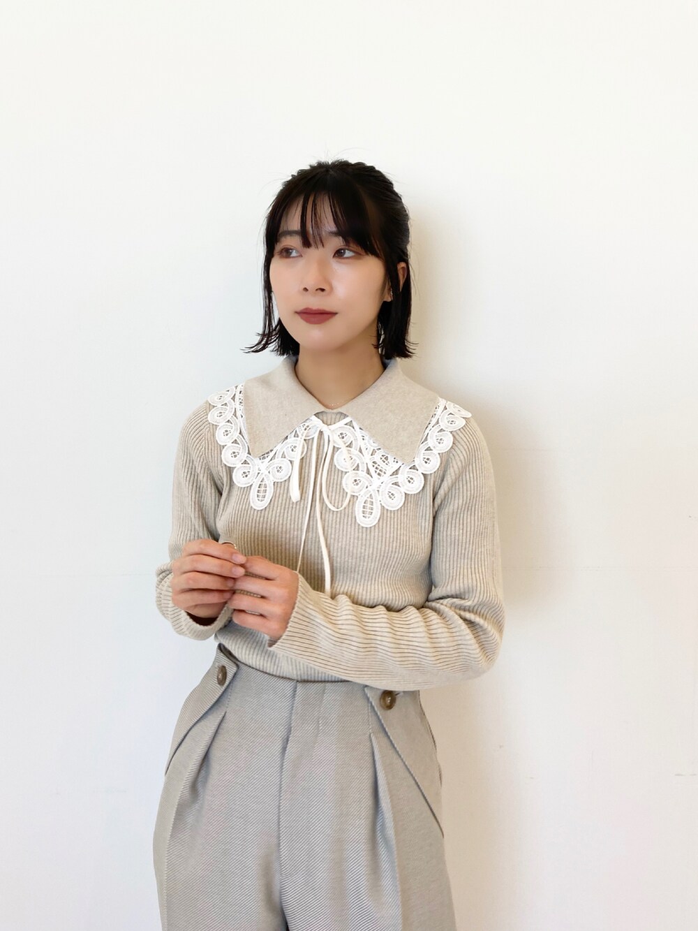 グレー系のその他パンツ、ホワイト系のニット/セーター、ベージュ系のブーツを着用したレディースの冬コーディネートの2枚目の写真