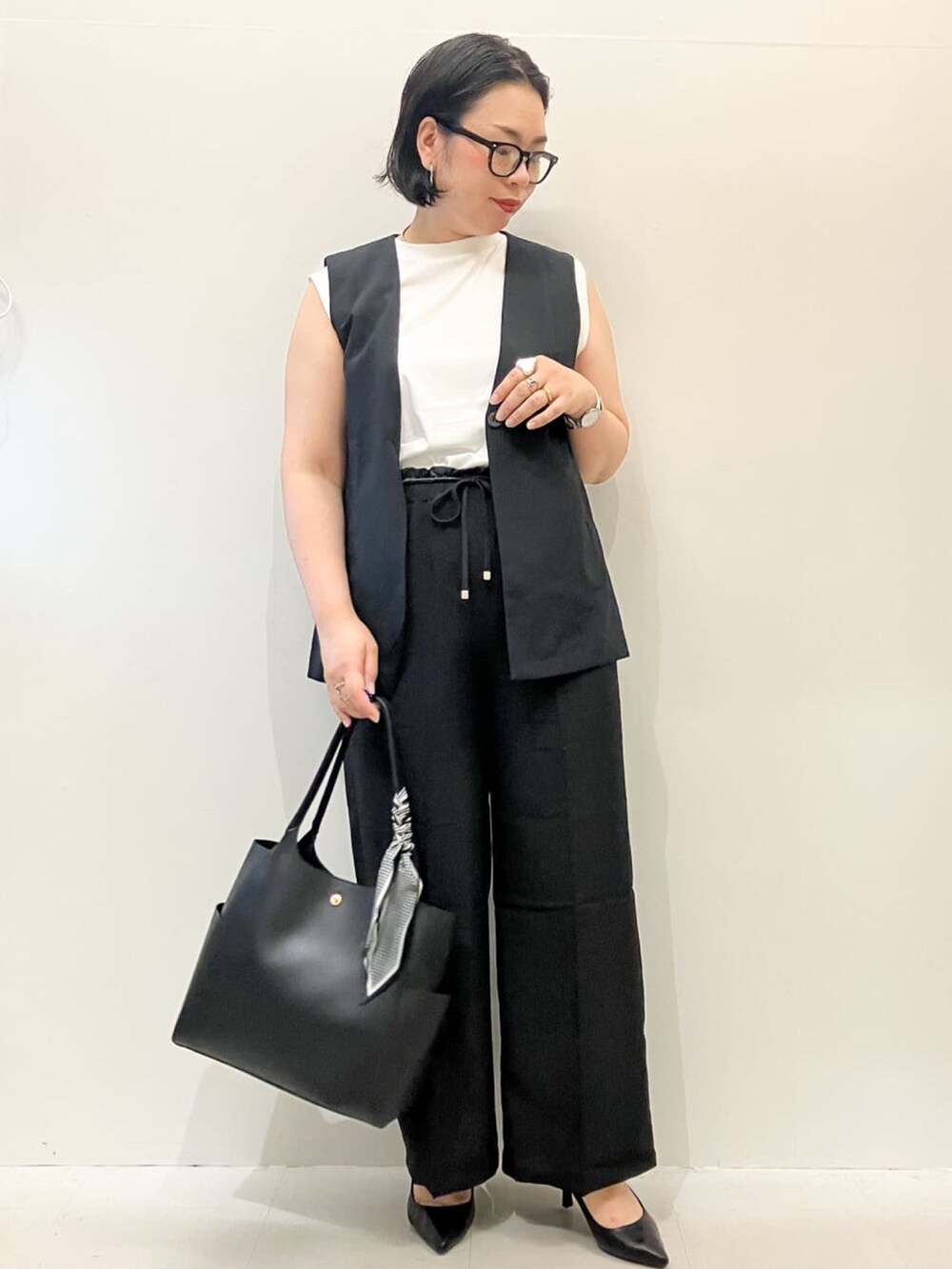 ホワイト系のTシャツ/カットソー、ブラック系のベスト、ブラック系のその他パンツを着用したレディースの夏コーディネートの2枚目の写真