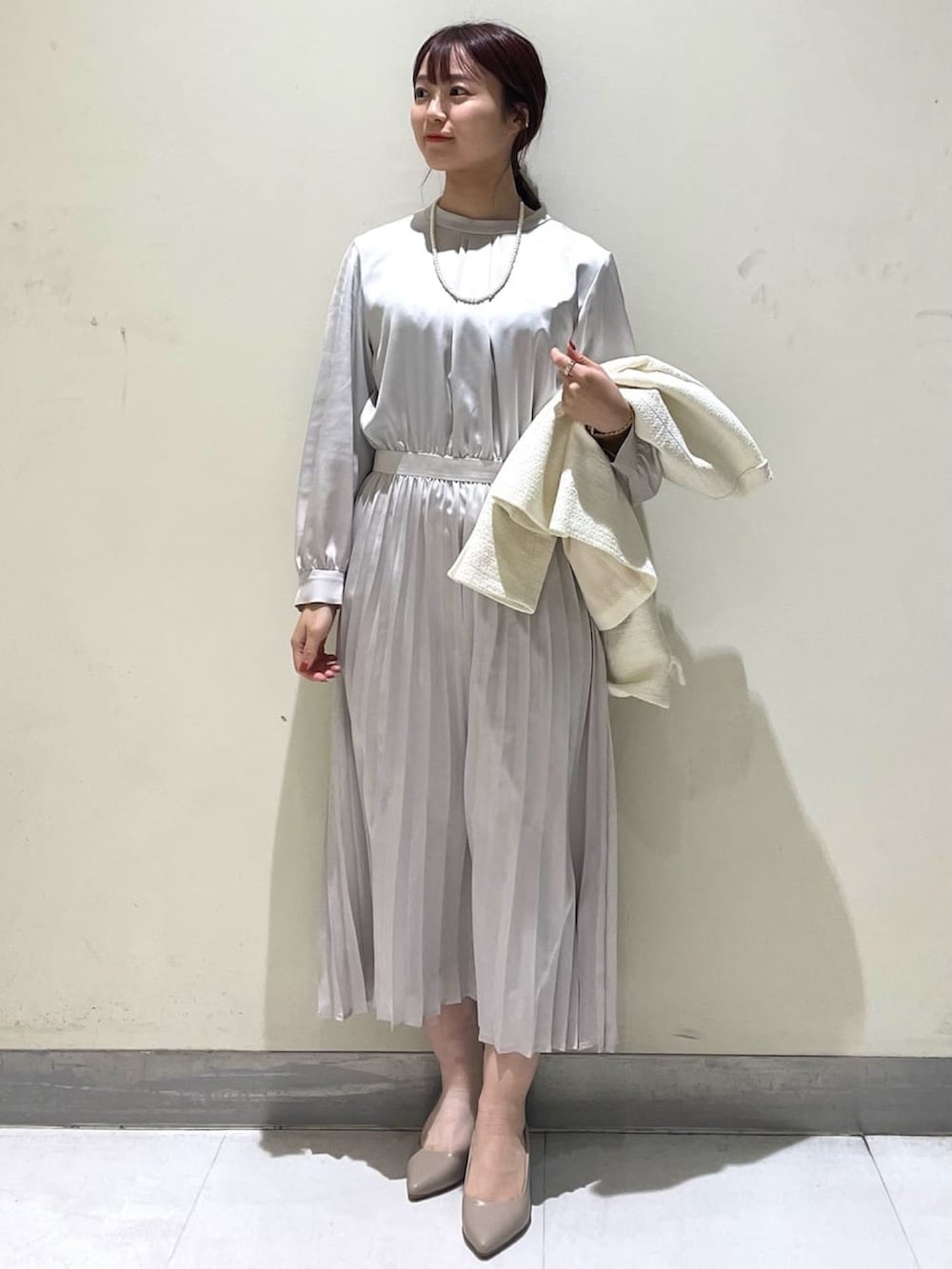 ホワイト系のノーカラージャケット、ベージュ系のワンピース、ベージュ系のショルダーバッグを着用したレディースの冬コーディネートの4枚目の写真