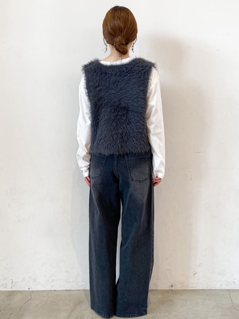 ホワイト系のTシャツ/カットソー、グレー系のベスト、ブラック系のデニムパンツを着用したレディースの秋コーディネートの3枚目の写真