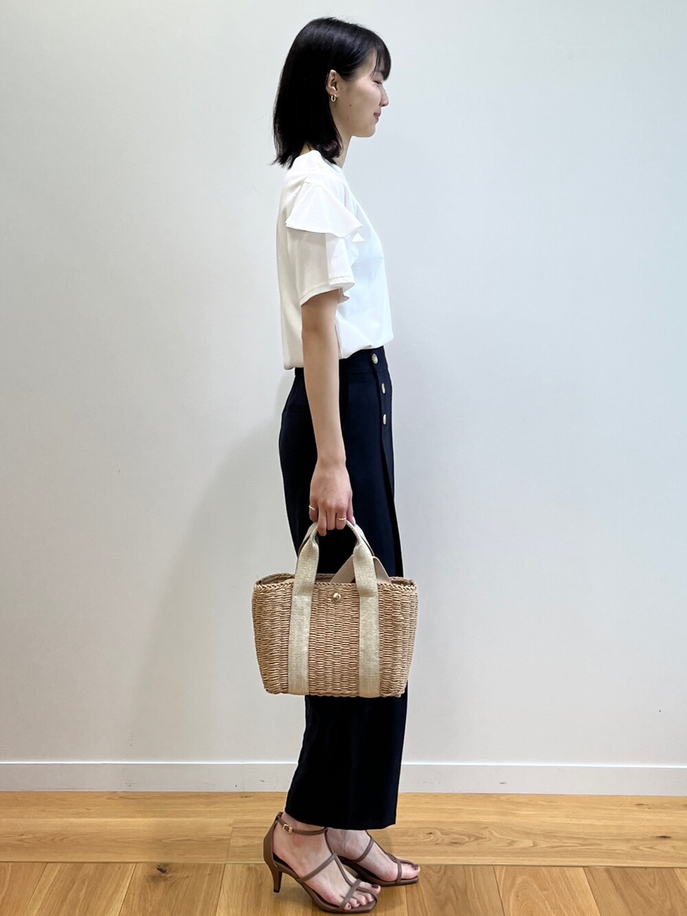 ブラウン系のサンダル、ホワイト系のTシャツ/カットソー、ゴールド系のトートバッグを着用したレディースの春コーディネートの2枚目の写真