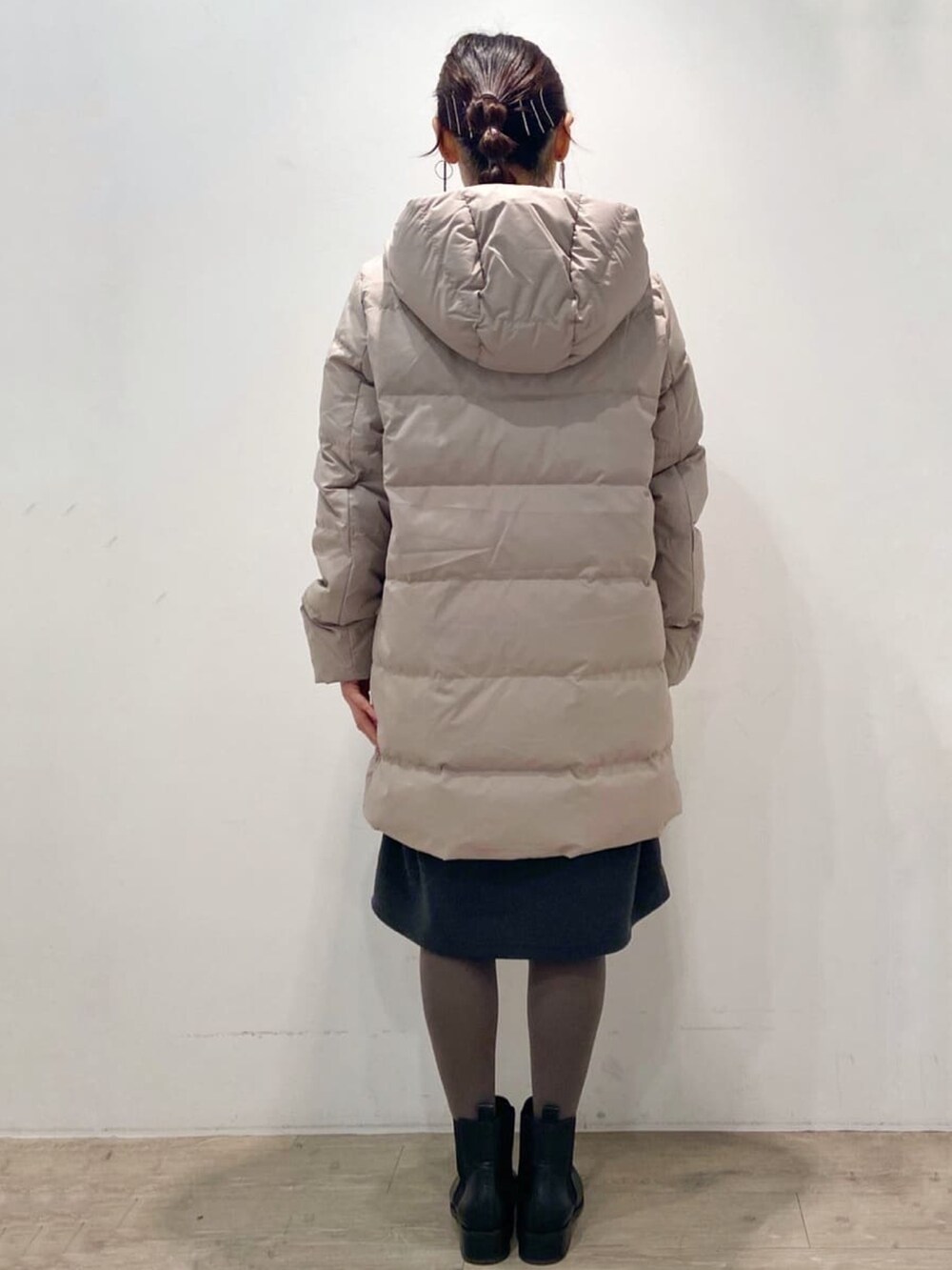 ベージュ系のダウンジャケット/コート、グレー系のワンピース、ブラック系のブーツを着用したレディースの冬コーディネートの4枚目の写真