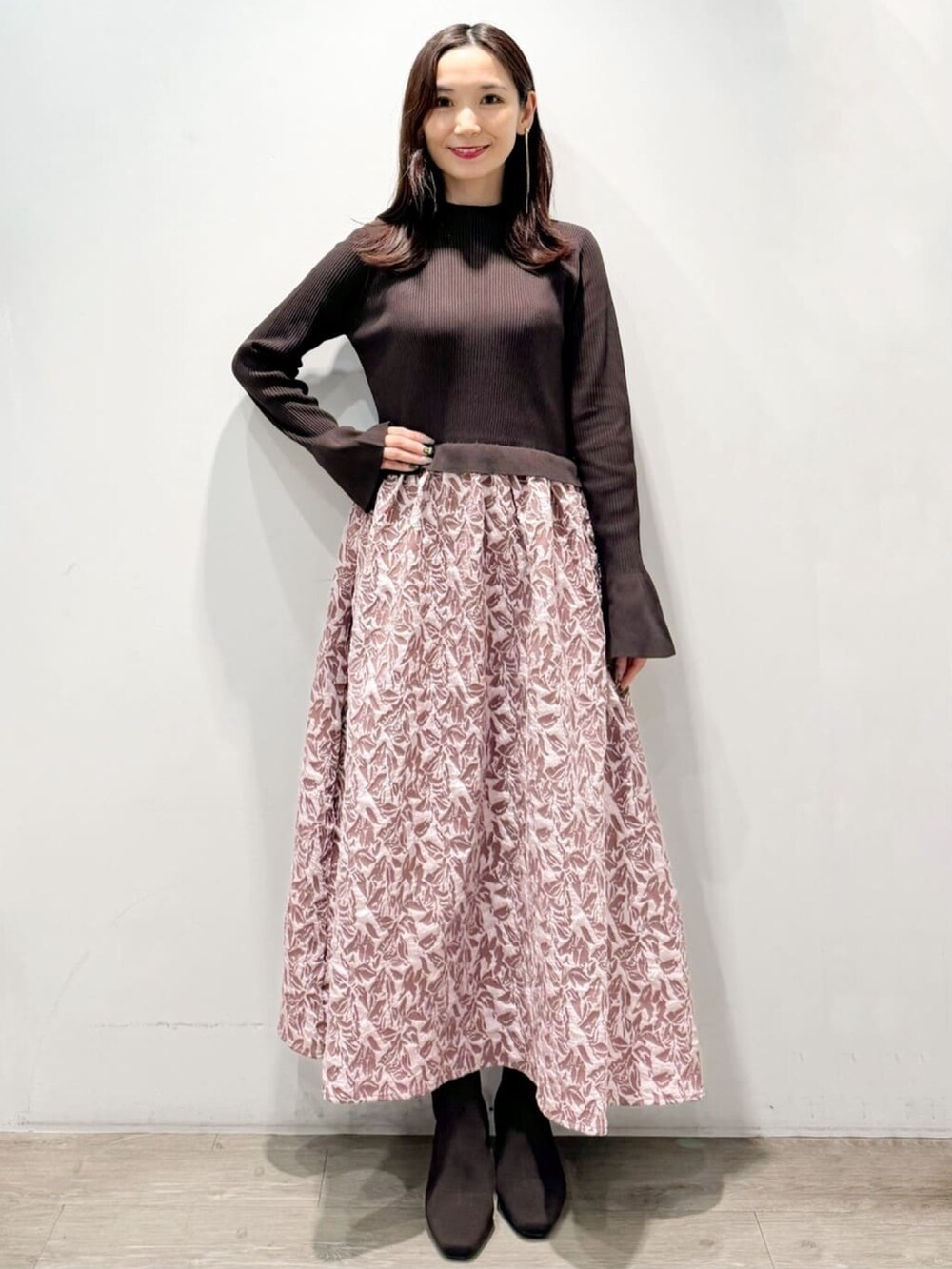 ピンク系のワンピース、ブラウン系のブーツを着用したレディースの秋コーディネートの2枚目の写真