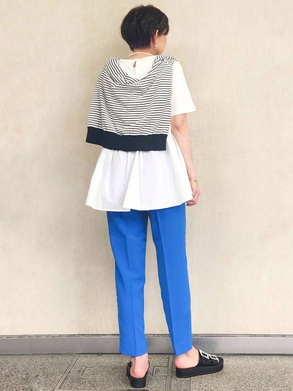 ブルー系のその他パンツ、ブラック系のサンダル、ホワイト系のTシャツ/カットソーを着用したレディースの春コーディネートの4枚目の写真