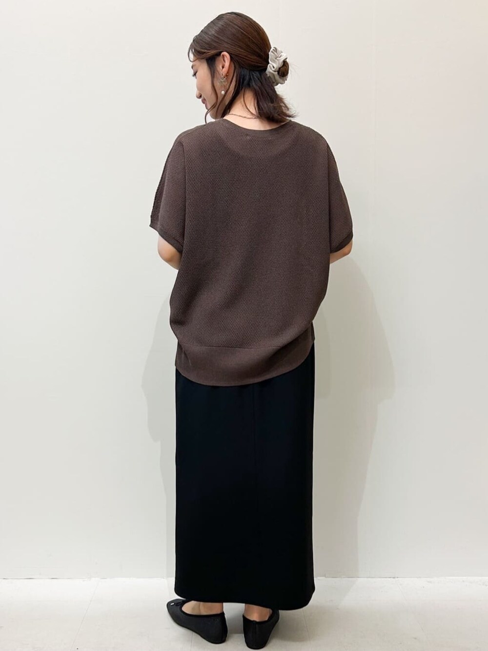 ブラウン系のニット/セーター、ブラック系のパンプス、ブラック系のスカートを着用したレディースの夏コーディネートの3枚目の写真