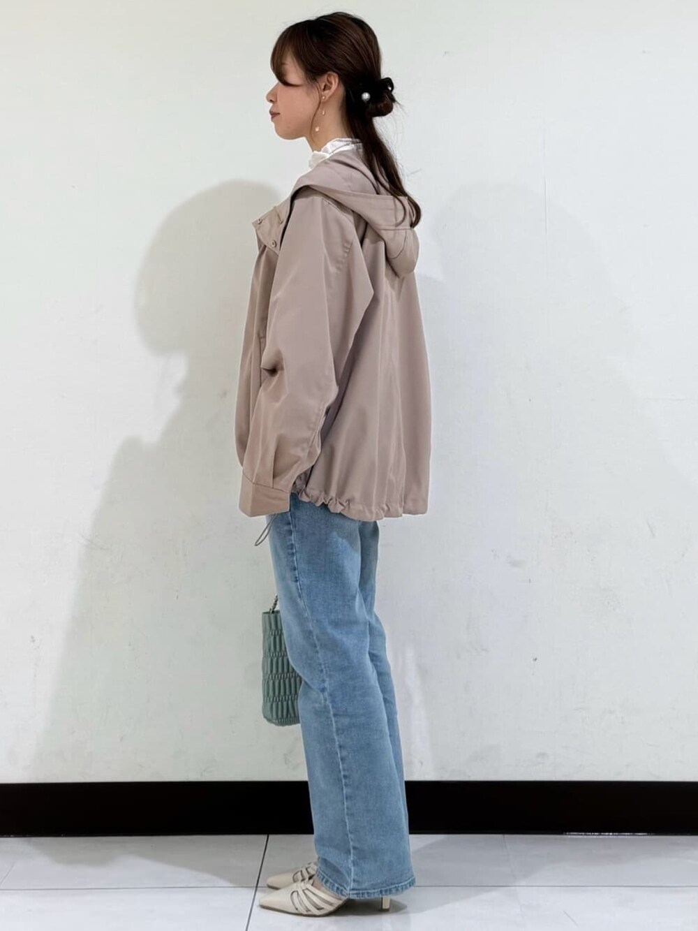 ベージュ系のブルゾン、グリーン系のショルダーバッグ、ホワイト系のTシャツ/カットソーを着用したレディースの春コーディネートの2枚目の写真