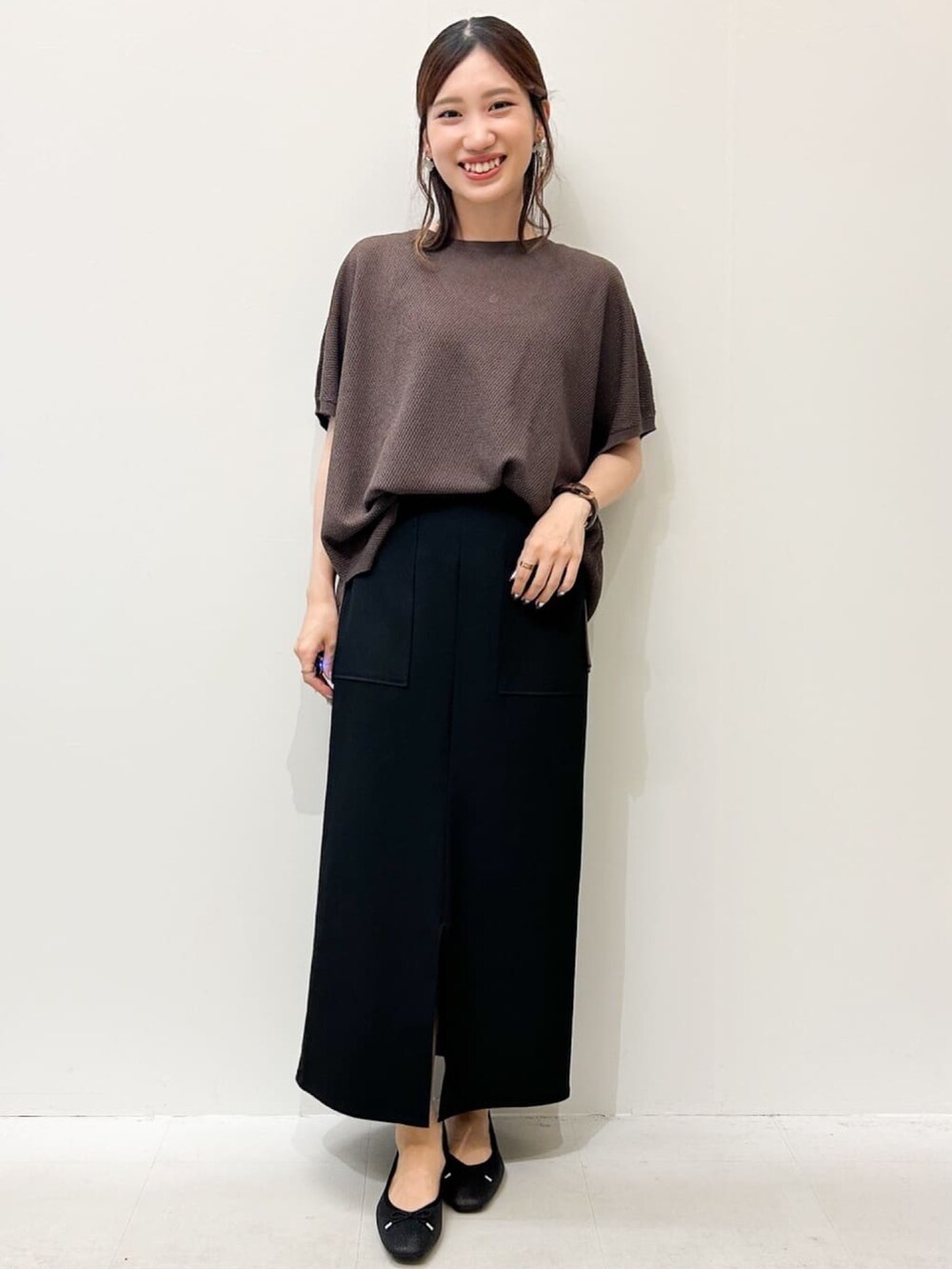 ブラウン系のニット/セーター、ブラック系のパンプス、ブラック系のスカートを着用したレディースの夏コーディネートの4枚目の写真