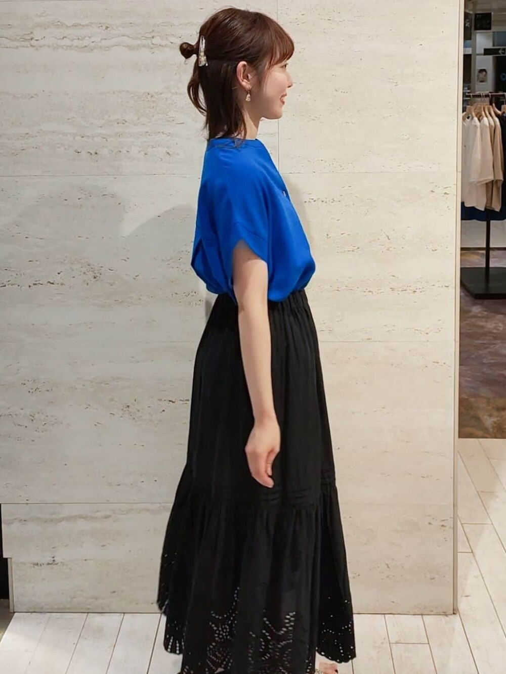 ブルー系のシャツ/ブラウス、ブラック系のスカート、ホワイト系のサンダルを着用したレディースの春コーディネートの4枚目の写真