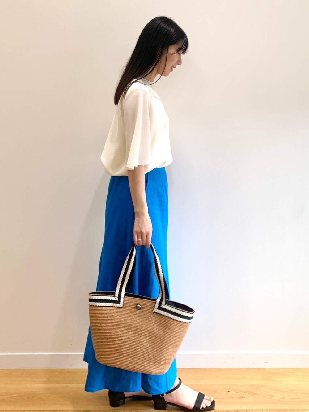 ホワイト系のシャツ/ブラウス、ブルー系のスカート、ブラック系のサンダルを着用したレディースの春コーディネートの2枚目の写真