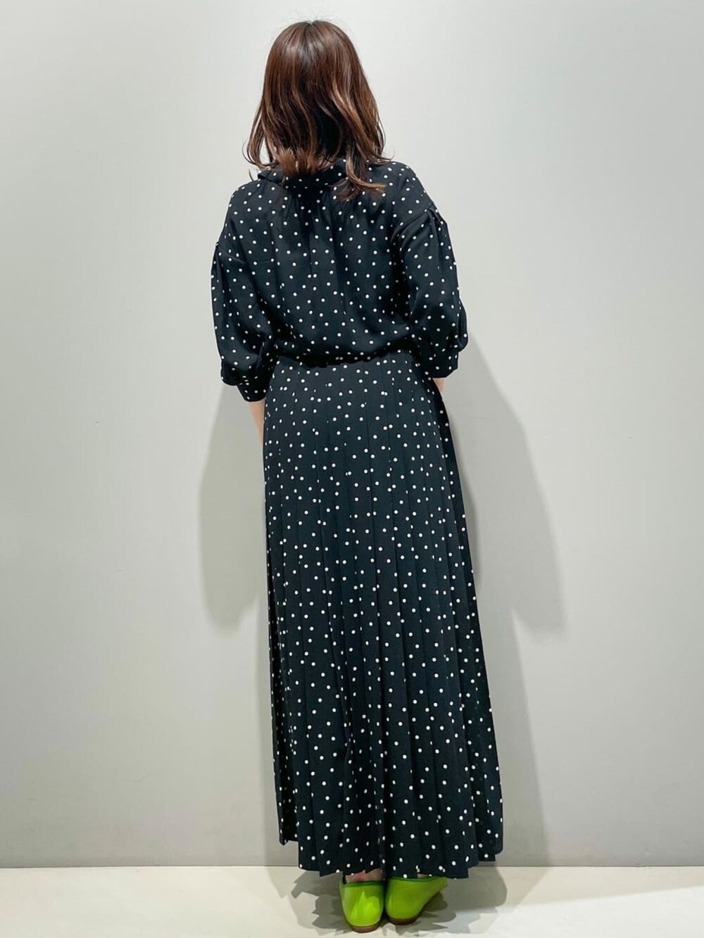 ブラック系のシャツ/ブラウス、ブラック系のスカート、グリーン系のパンプスを着用したレディースの春コーディネートの2枚目の写真