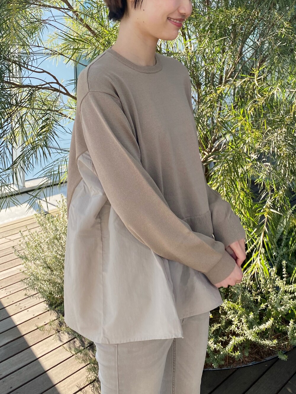 ベージュ系のデニムパンツ、ベージュ系のニット/セーター、ブラック系のショルダーバッグを着用したレディースの冬コーディネートの2枚目の写真