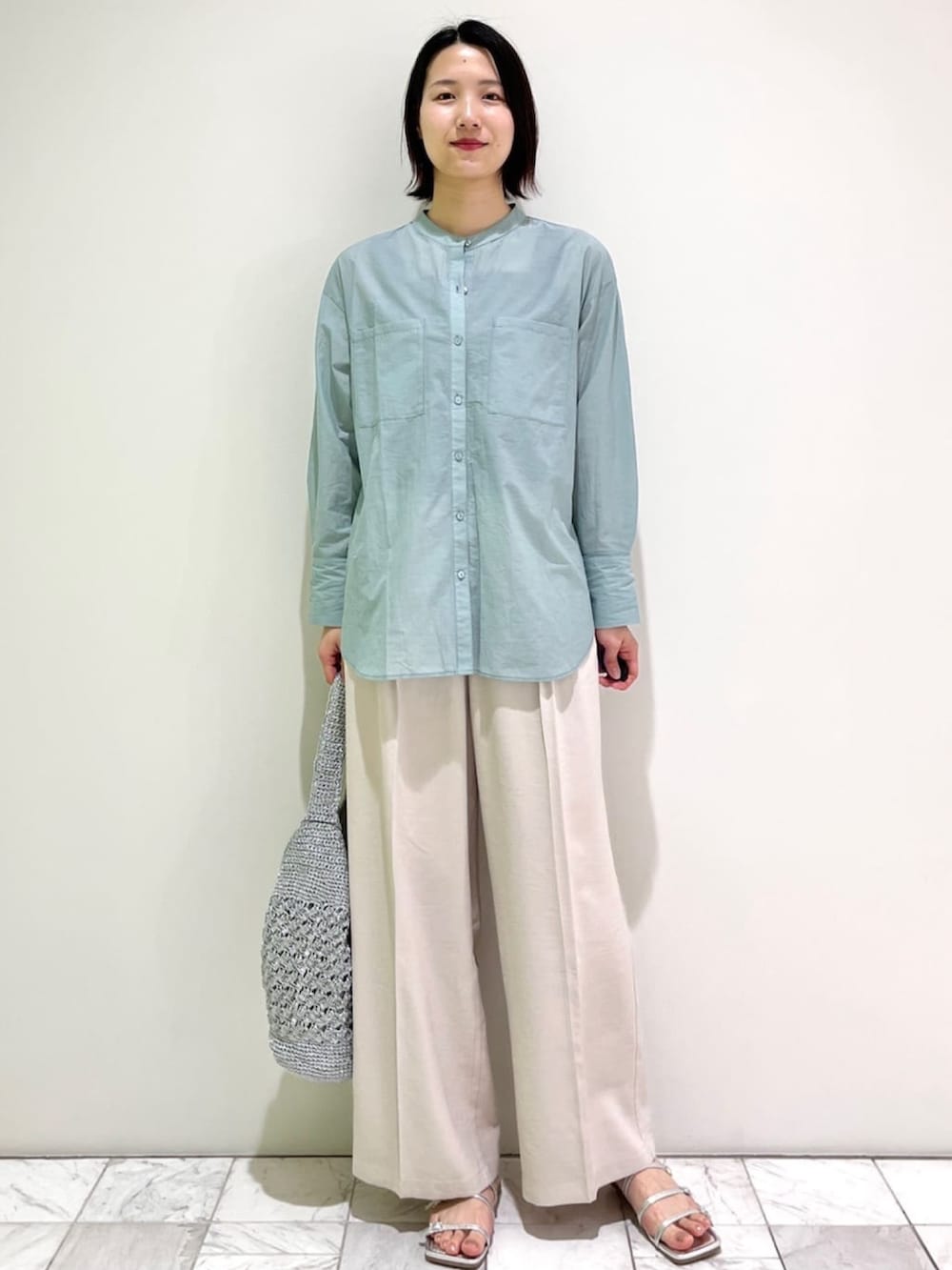 グリーン系のシャツ/ブラウス、ベージュ系のその他パンツ、シルバー系のトートバッグを着用したレディースの春コーディネートの2枚目の写真