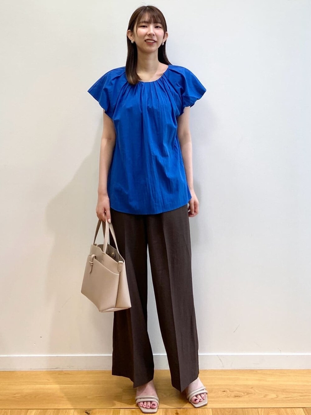ブルー系のシャツ/ブラウス、ブラウン系のその他パンツ、ベージュ系のサンダルを着用したレディースの夏コーディネートの2枚目の写真