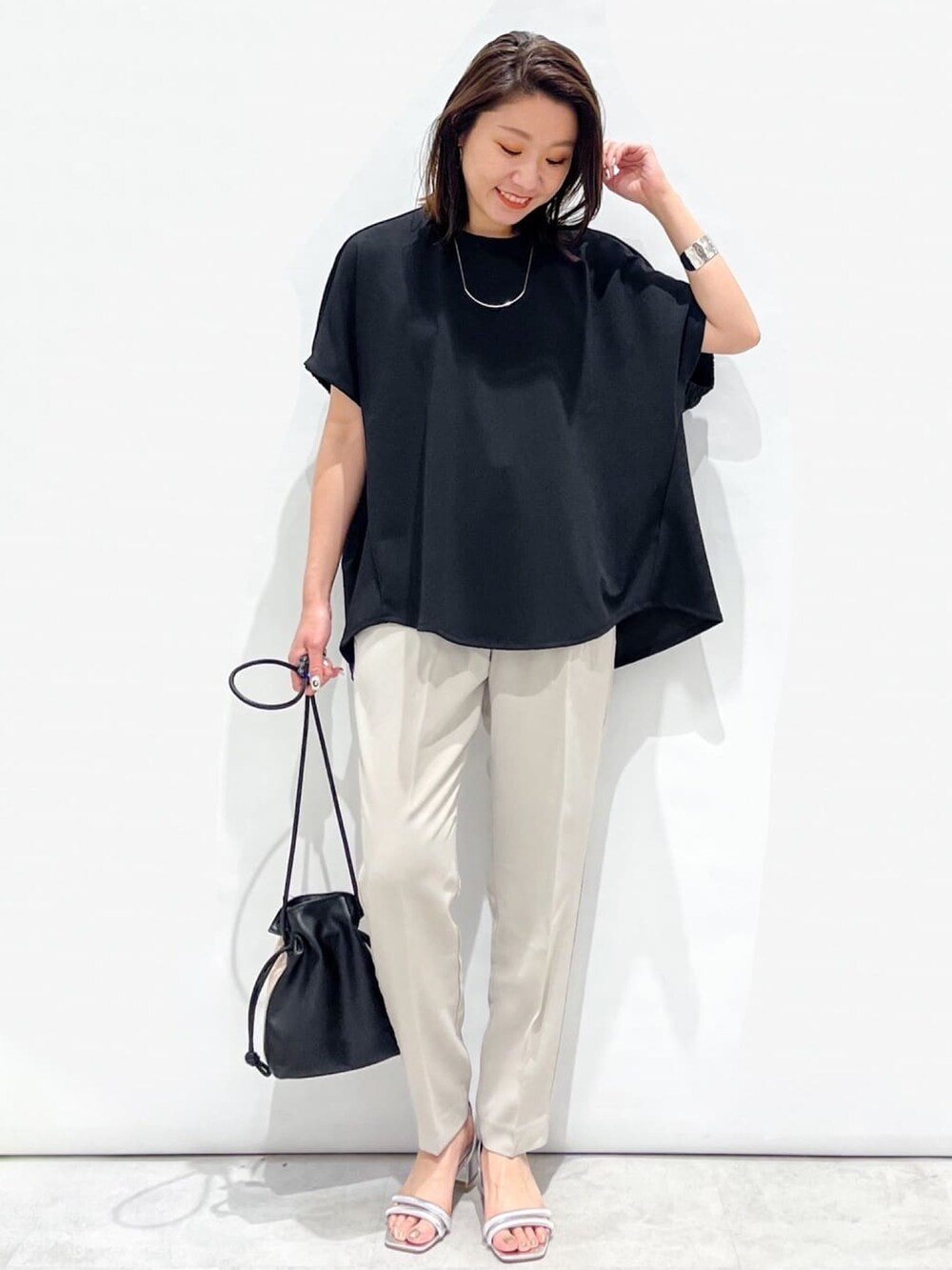 ブラック系のTシャツ/カットソー、グレー系のその他パンツ、シルバー系のサンダルを着用したレディースの春コーディネートの5枚目の写真