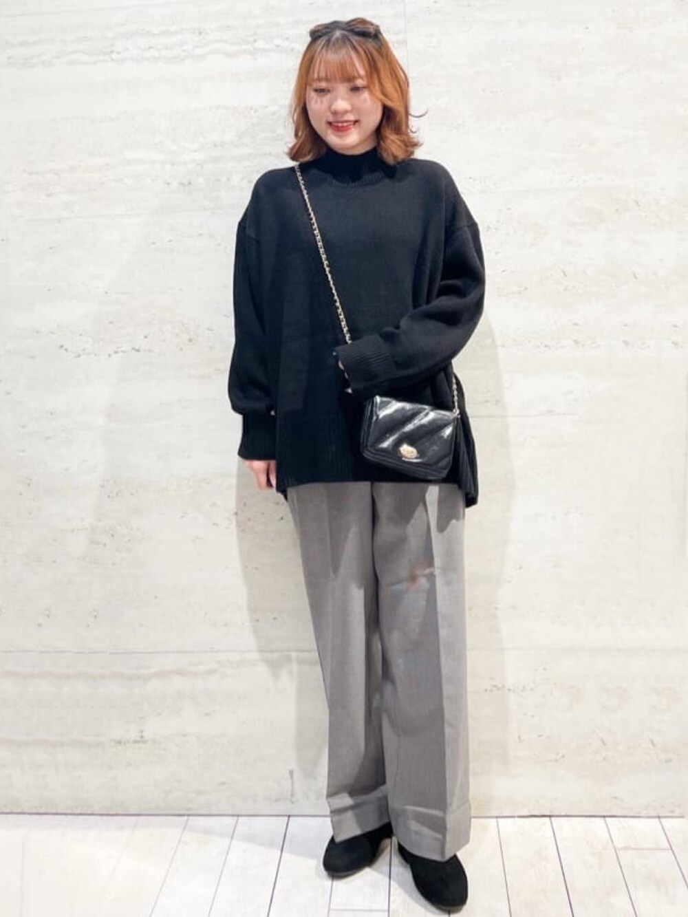ブラウン系のピーコート、ブラック系のニット/セーター、グレー系のその他パンツを着用したレディースの冬コーディネートの2枚目の写真