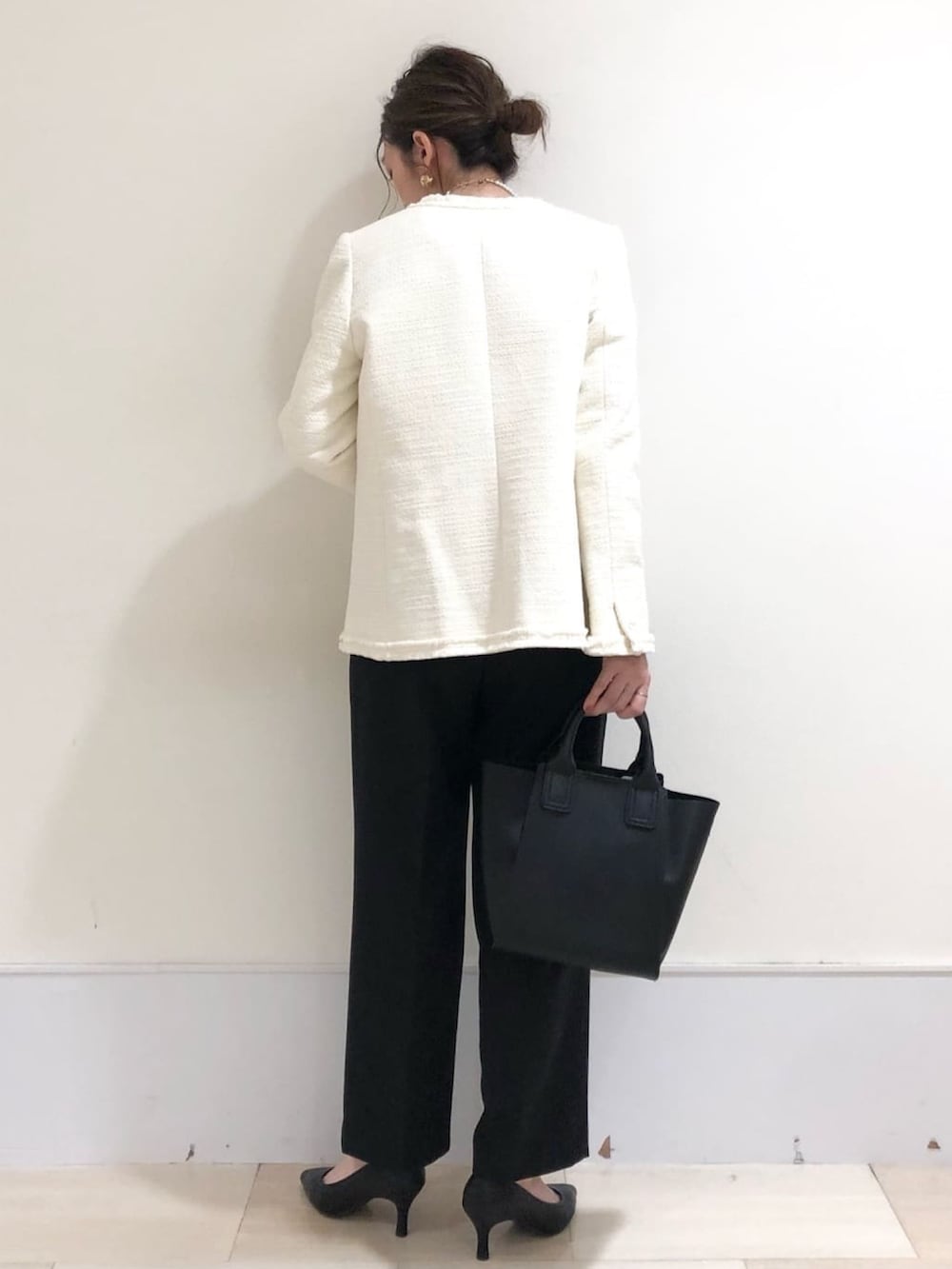 ホワイト系のノーカラージャケット、ホワイト系のシャツ/ブラウス、ブラック系のその他パンツを着用したレディースの冬コーディネートの2枚目の写真