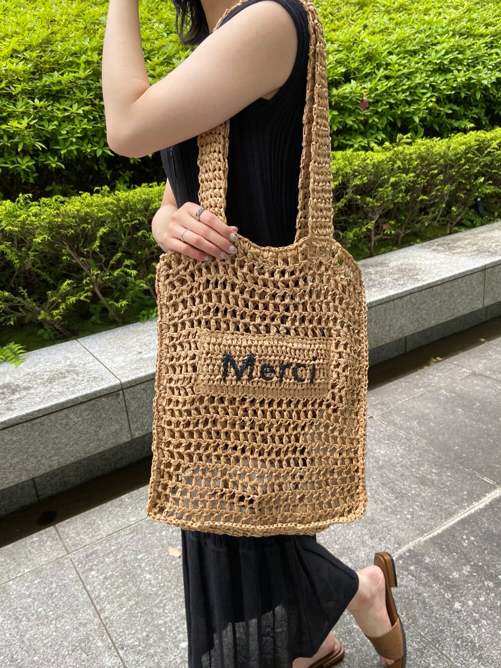 ブラック系のワンピース、ベージュ系のトートバッグ、その他のサンダルを着用したレディースの春コーディネートの2枚目の写真