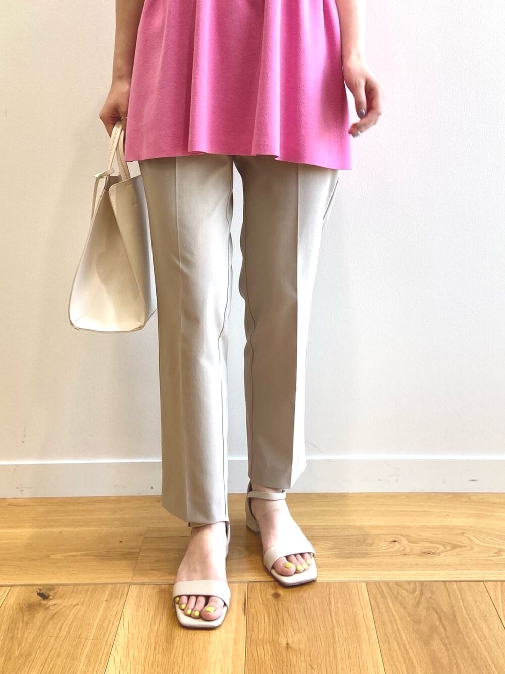 ピンク系のニット/セーター、ベージュ系のその他パンツ、ホワイト系のトートバッグを着用したレディースの夏コーディネートの5枚目の写真