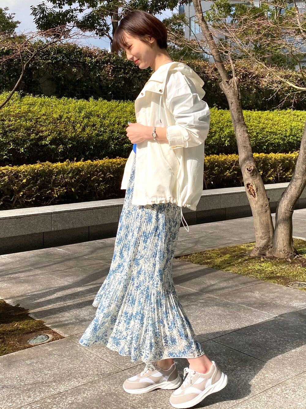 ホワイト系のブルゾン、ブルー系のニット/セーター、ブルー系のスカートを着用したレディースの春コーディネートの2枚目の写真