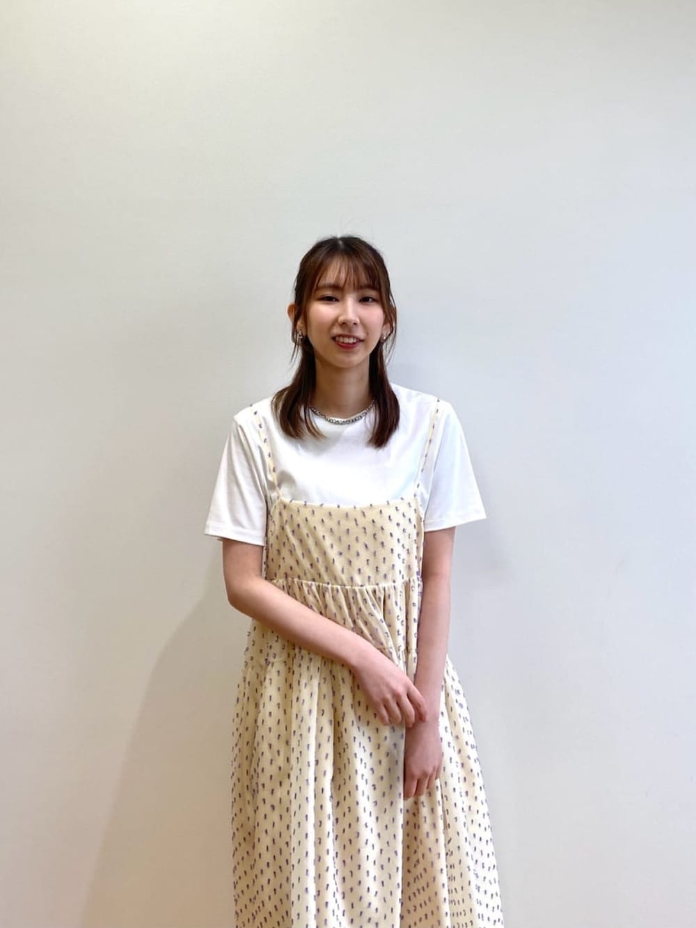 ホワイト系のワンピース、ホワイト系のTシャツ/カットソー、シルバー系のサンダルを着用したレディースの春コーディネートの4枚目の写真