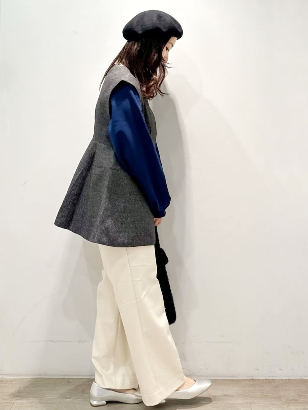 ブラック系のハンドバッグ、ホワイト系のその他パンツ、グレー系のベストを着用したレディースの秋コーディネートの4枚目の写真