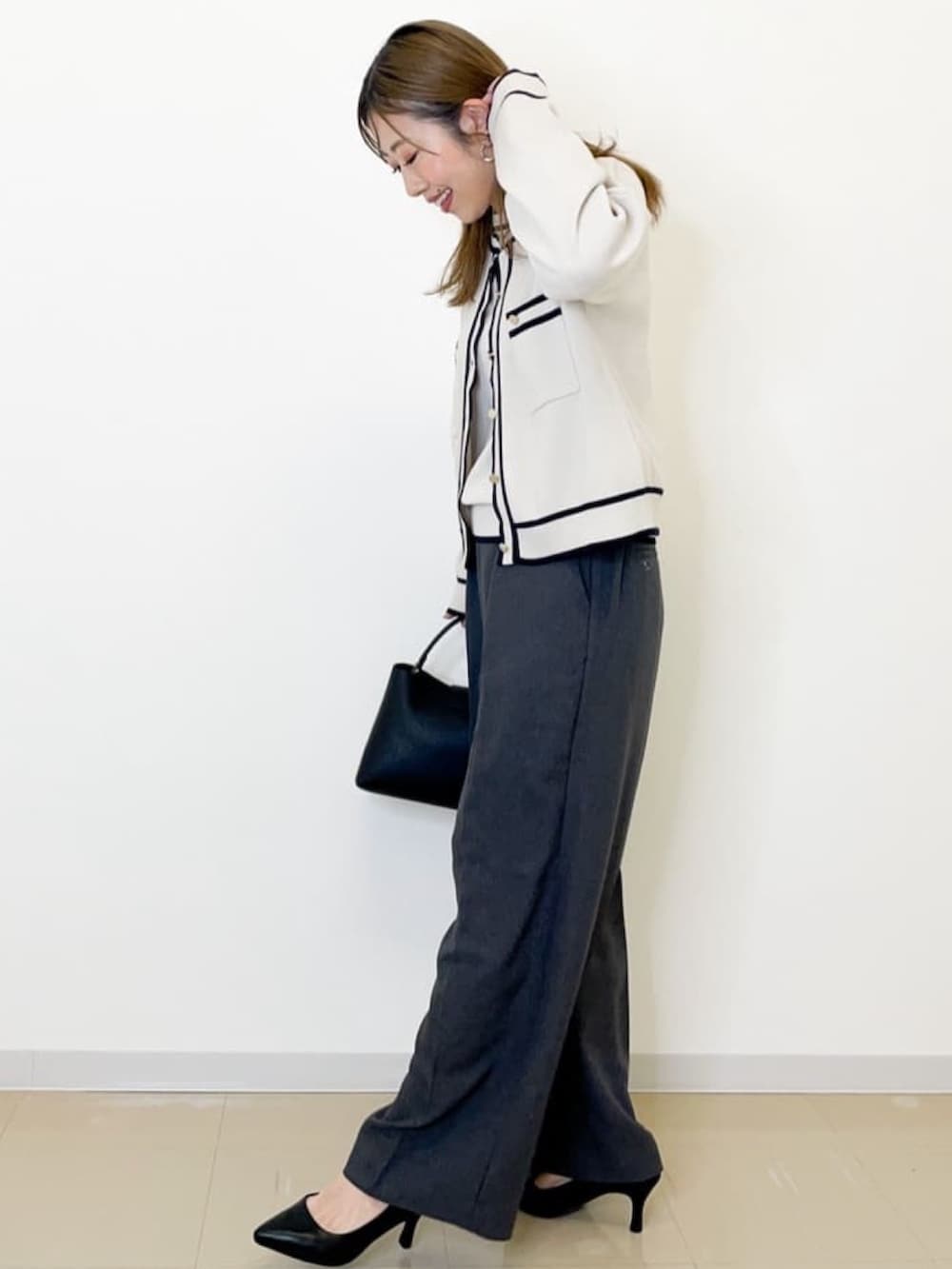 グレー系のその他パンツ、ホワイト系のカーディガン/ボレロ、ホワイト系のニット/セーターを着用したレディースの春コーディネートの2枚目の写真