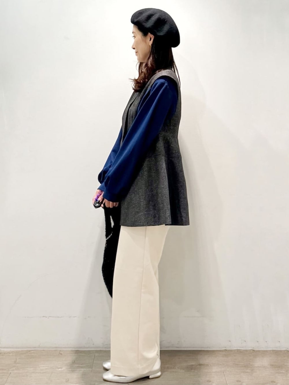 ブラック系のハンドバッグ、ホワイト系のその他パンツ、グレー系のベストを着用したレディースの秋コーディネートの5枚目の写真