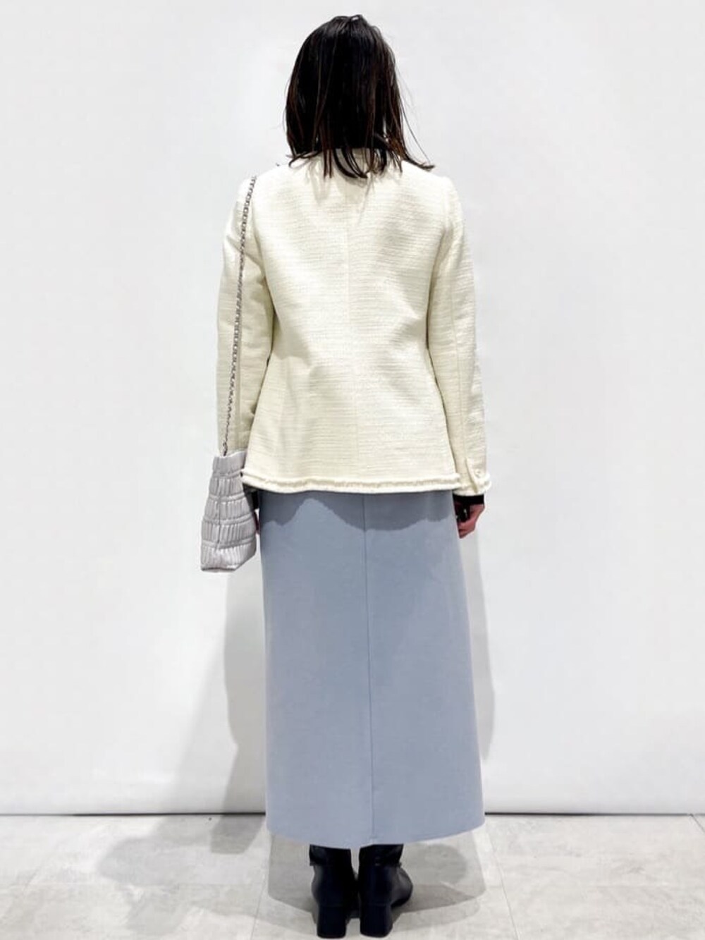 ブラック系のニット/セーター、ホワイト系のノーカラージャケット、グレー系のショルダーバッグを着用したレディースの冬コーディネートの3枚目の写真