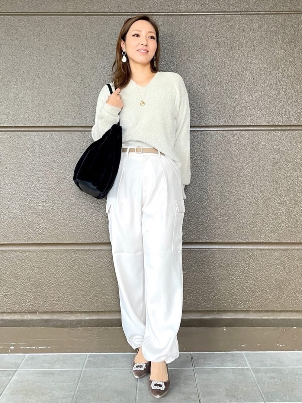 ホワイト系のその他パンツ、ブラック系のショルダーバッグ、ベージュ系のニット/セーターを着用したレディースの冬コーディネートの2枚目の写真