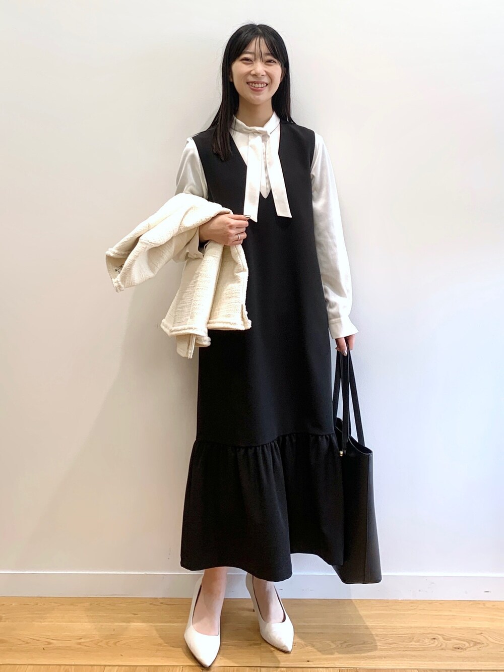 ブラック系のスカート、ホワイト系のノーカラージャケット、ホワイト系のシャツ/ブラウスを着用したレディースの冬コーディネートの2枚目の写真