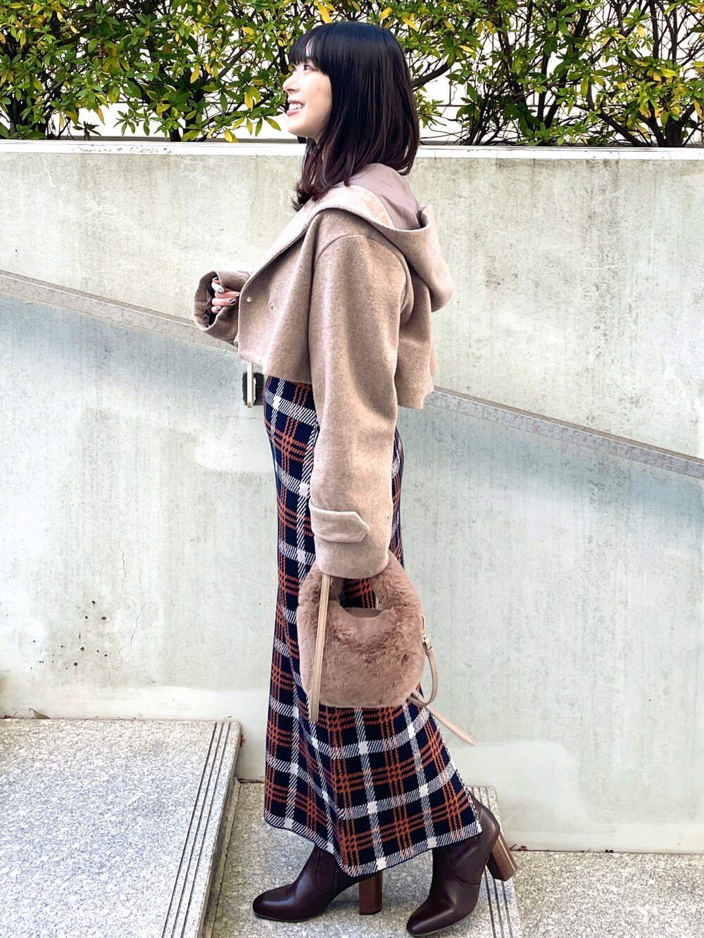 ブラウン系のその他アウター、ブラック系のニット/セーター、ブラウン系のショルダーバッグを着用したレディースの冬コーディネートの2枚目の写真