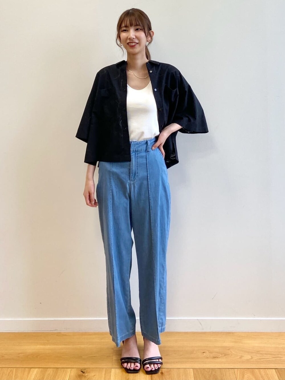 ブルー系のデニムパンツ、ブラック系のサンダル、ブラック系のシャツ/ブラウスを着用したレディースの夏コーディネートの2枚目の写真