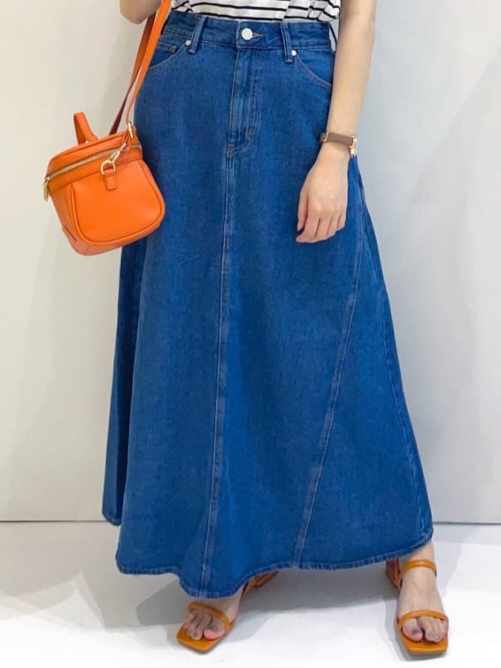 ホワイト系のTシャツ/カットソー、ブルー系のスカート、レッド系のショルダーバッグを着用したレディースの春コーディネートの3枚目の写真