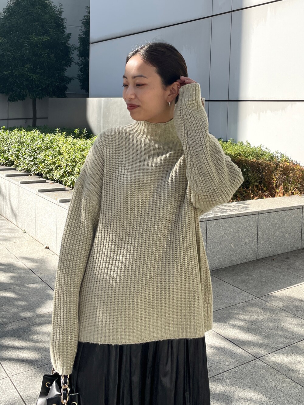 ベージュ系のニット/セーター、グレー系のスカート、ブラック系のブーツを着用したレディースの冬コーディネートの4枚目の写真