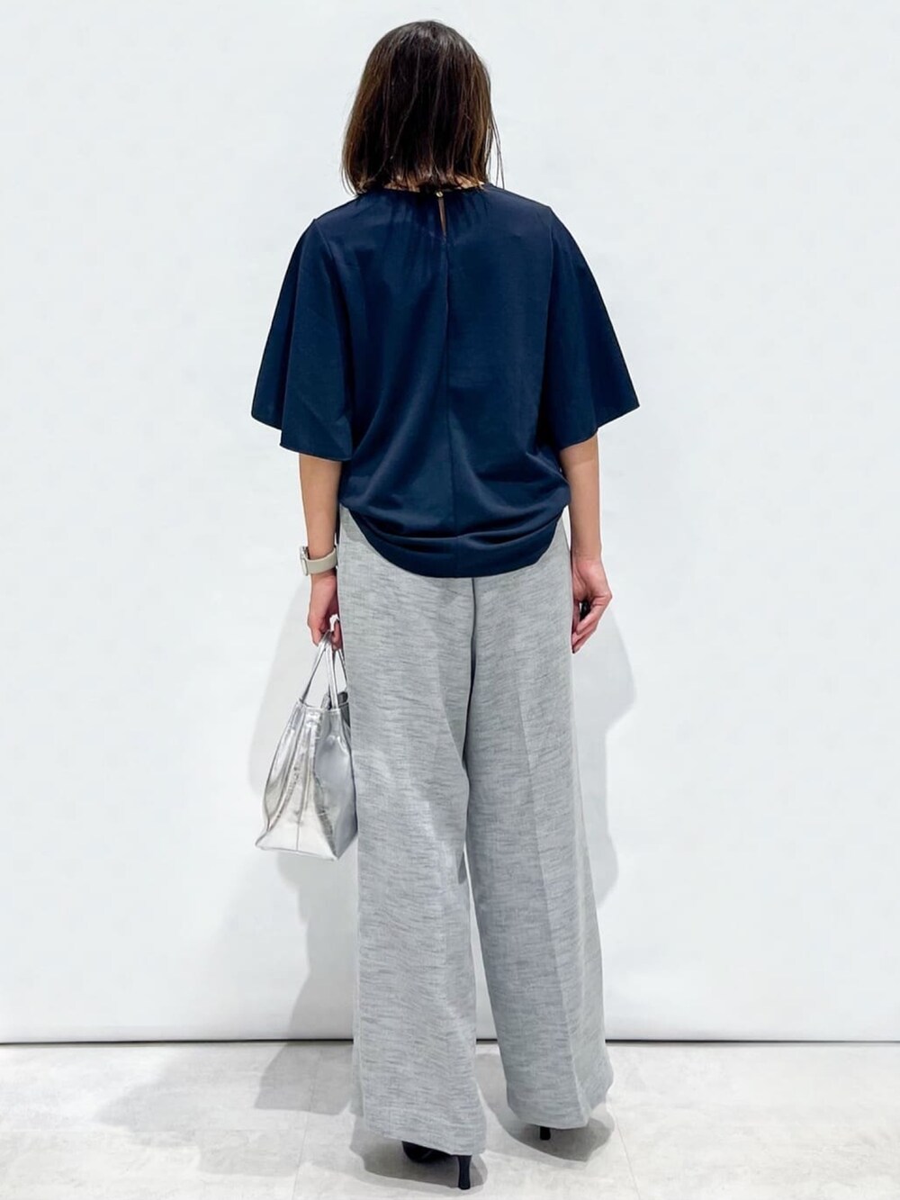 ブラック系のその他パンツ、ブラック系のパンプス、シルバー系のトートバッグを着用したレディースの夏コーディネートの6枚目の写真