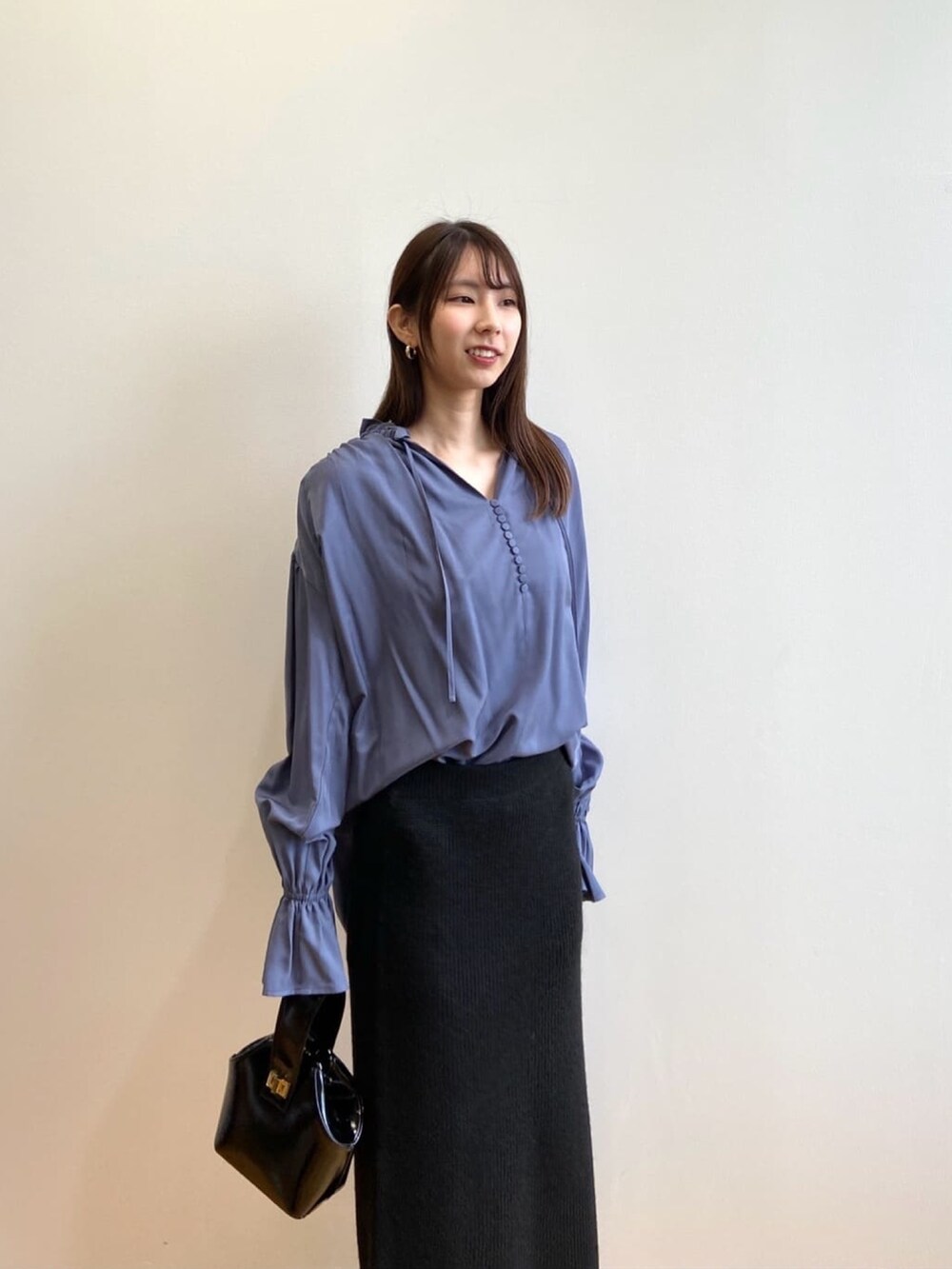 ブラック系のショルダーバッグ、ブルー系のシャツ/ブラウス、ブラック系のパンプスを着用したレディースの秋コーディネートの5枚目の写真