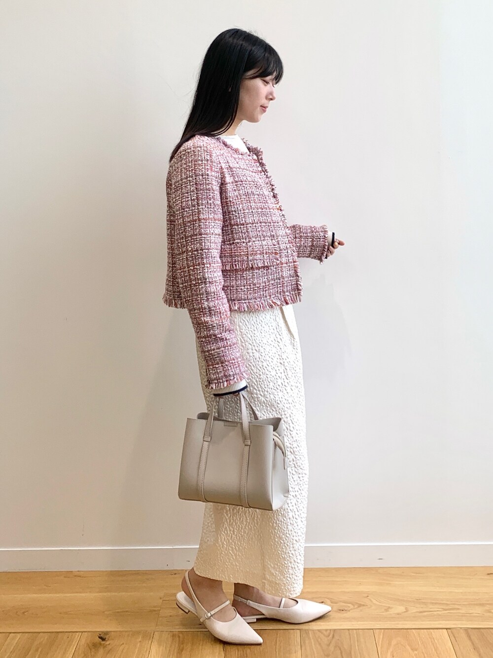 ホワイト系のワンピース、ホワイト系のニット/セーター、ベージュ系のサンダルを着用したレディースの春コーディネートの2枚目の写真