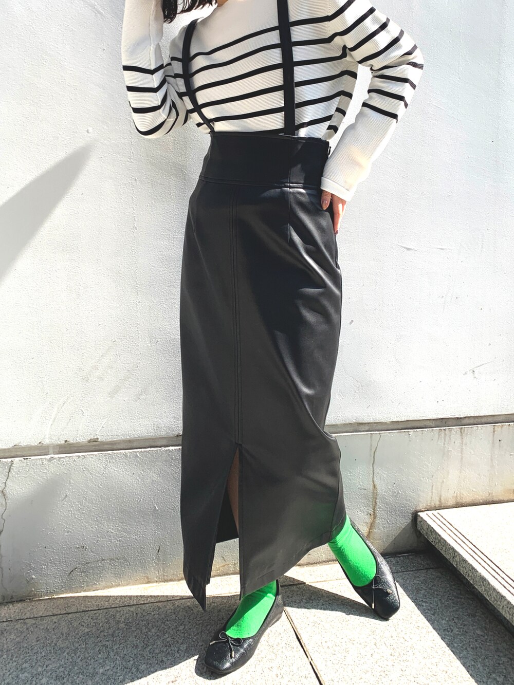 ホワイト系のニット/セーター、ブラック系のスカート、ブラック系のドレスシューズを着用したレディースの春コーディネートの2枚目の写真